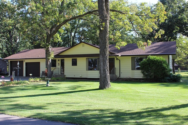 ranch-style house featuring a garage and a front lawn