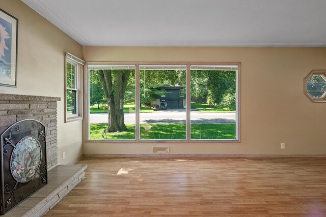4700 Glenwood Ave, Golden Valley, MN 55422 - unfurnished living room with light wood-style floors, a fireplace with raised hearth, and ornamental molding