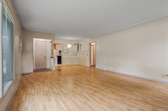 unfurnished living room with light hardwood / wood-style floors and crown molding