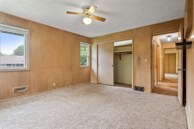 4700 Glenwood Ave, Golden Valley, MN 55422 - unfurnished bedroom featuring carpet floors, wooden walls, a closet, and ceiling fan