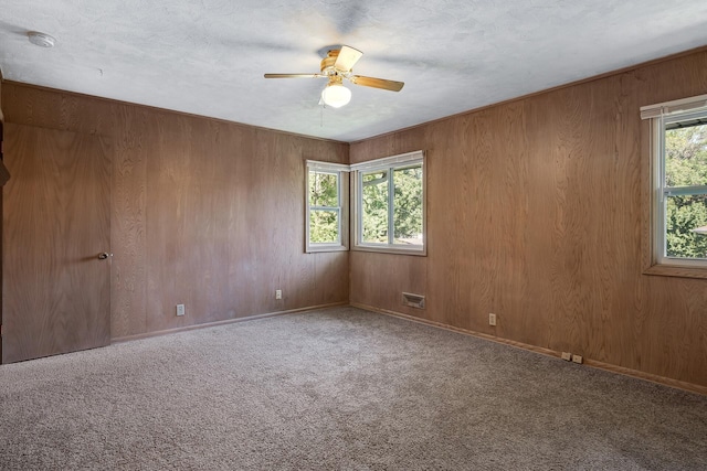 4700 Glenwood Ave, Golden Valley, MN 55422 - carpeted empty room with a ceiling fan, a smoke detector, and wooden walls
