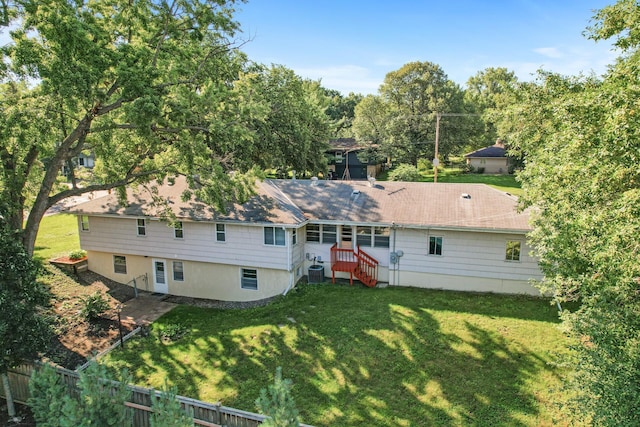 rear view of property featuring a lawn and central AC