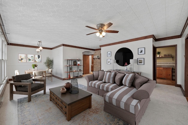 carpeted living room with ceiling fan and ornamental molding