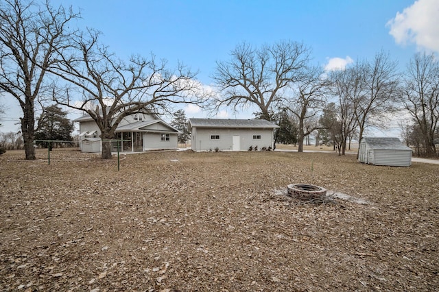 view of yard featuring a fire pit and a storage shed