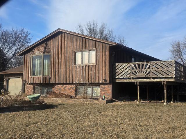 view of side of home with a yard and a garage