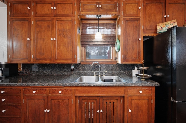 kitchen featuring pendant lighting, black fridge, and sink