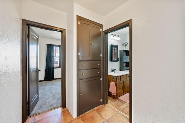 hallway with sink and light tile patterned floors