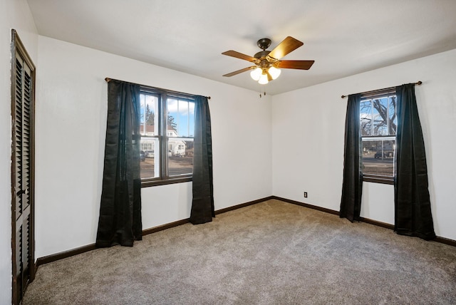 carpeted spare room featuring ceiling fan and a healthy amount of sunlight