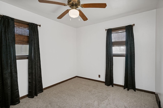 carpeted spare room featuring ceiling fan