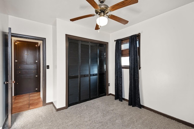 unfurnished bedroom featuring carpet, ceiling fan, and a closet