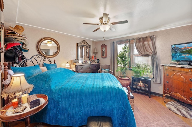 bedroom featuring wood-type flooring, ceiling fan, and ornamental molding