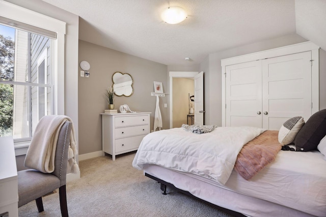 carpeted bedroom with a closet and a textured ceiling