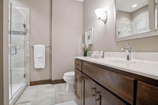 bathroom featuring vanity, toilet, and a shower with shower door