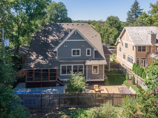 rear view of house featuring a sunroom and a patio