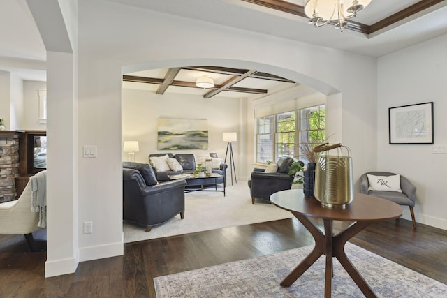 living room with dark wood-type flooring, coffered ceiling, an inviting chandelier, and beam ceiling