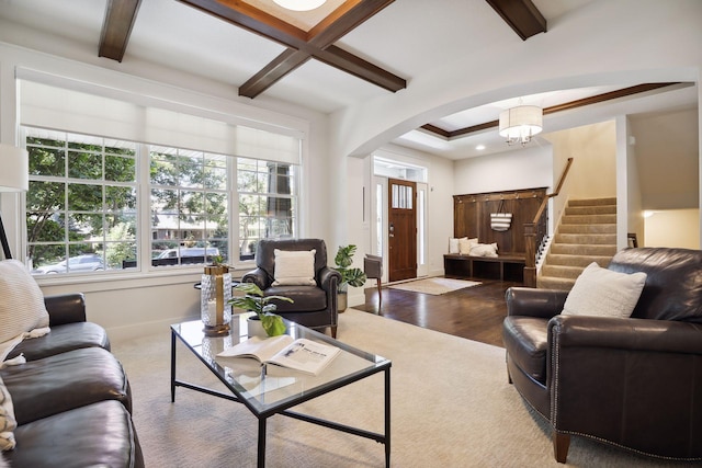 living room with beamed ceiling, wood-type flooring, coffered ceiling, and a chandelier