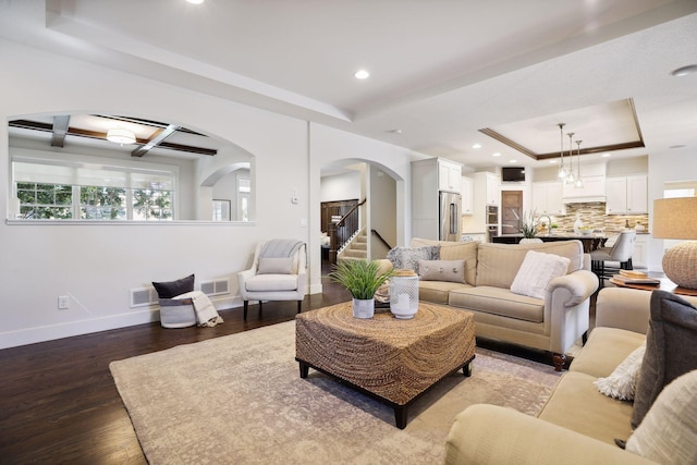 living room with hardwood / wood-style flooring, a raised ceiling, and beamed ceiling