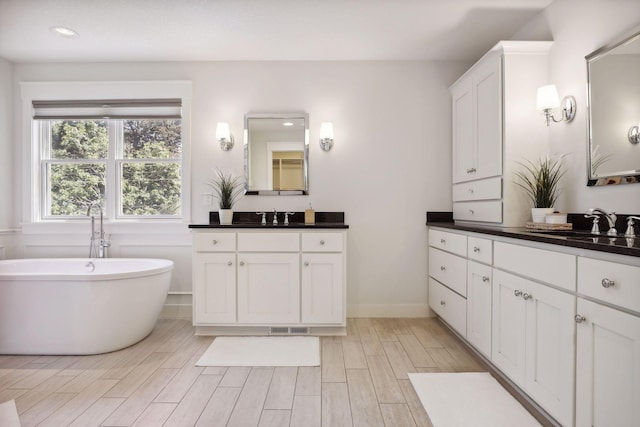 bathroom featuring vanity and a tub