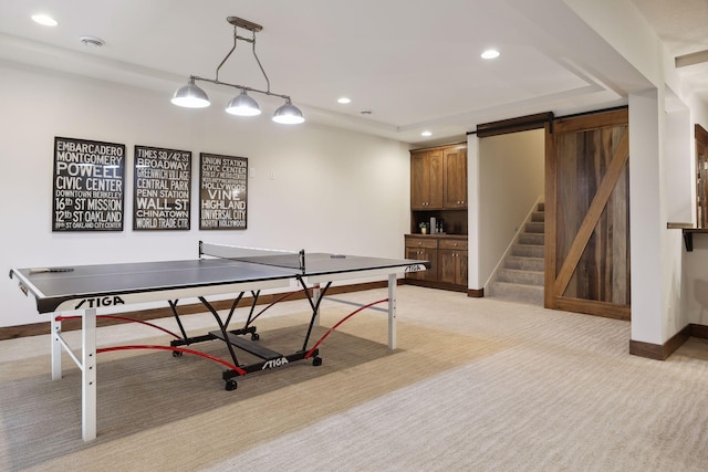 rec room with light colored carpet and a barn door