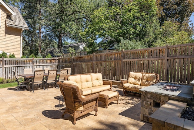 view of patio with an outdoor living space with a fire pit