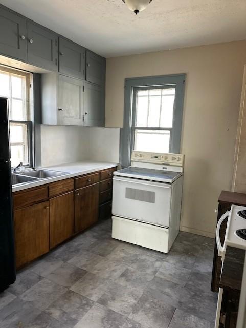 kitchen featuring black fridge and white electric range