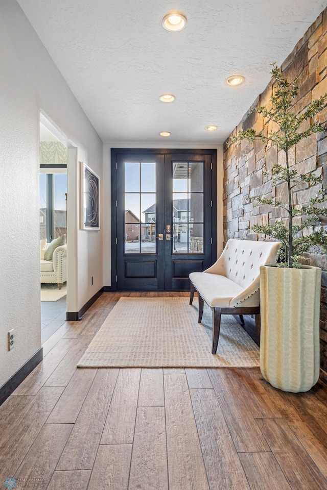 interior space featuring french doors, a healthy amount of sunlight, and a textured ceiling