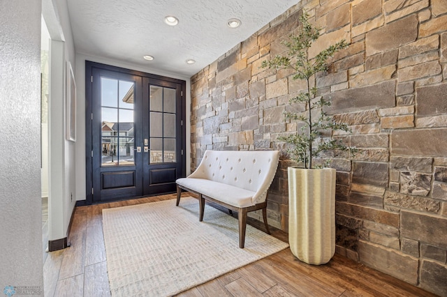 entrance foyer featuring hardwood / wood-style flooring, a textured ceiling, and french doors