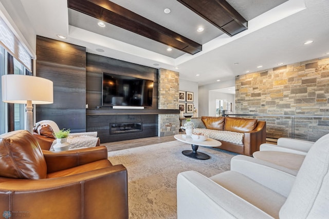 living room featuring beamed ceiling and a fireplace