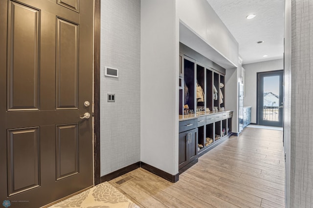 entrance foyer with a textured ceiling and light hardwood / wood-style flooring