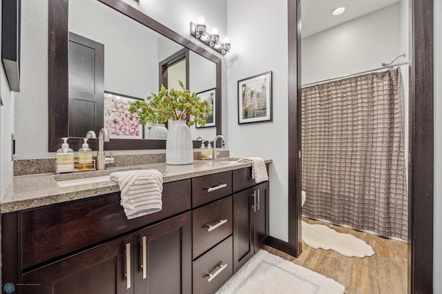 bathroom featuring vanity, curtained shower, and wood-type flooring