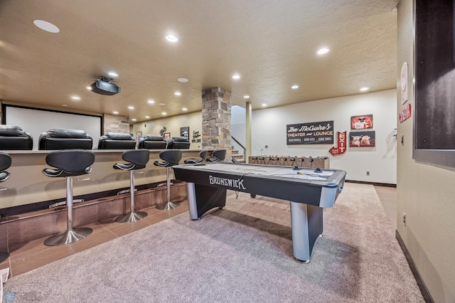 recreation room featuring ornate columns, light tile patterned flooring, and a textured ceiling