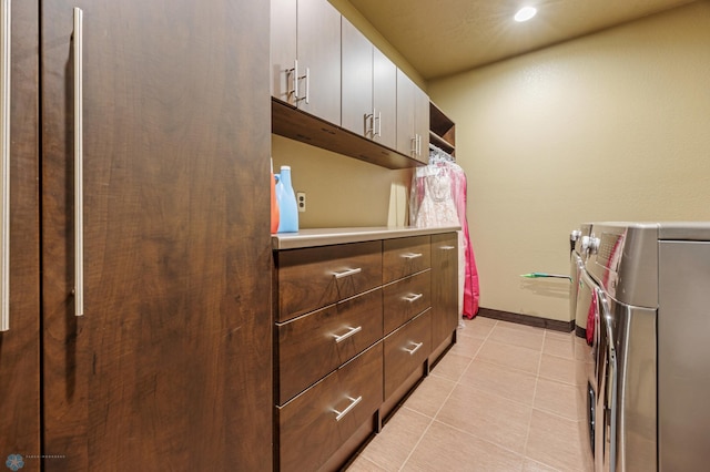 kitchen featuring white cabinets, separate washer and dryer, and light tile patterned floors