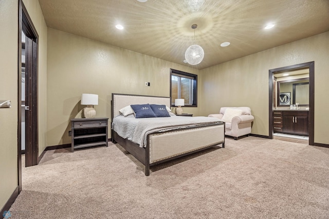 bedroom featuring light carpet, an inviting chandelier, and sink