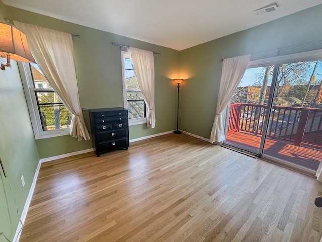 unfurnished room with a wealth of natural light and light hardwood / wood-style floors