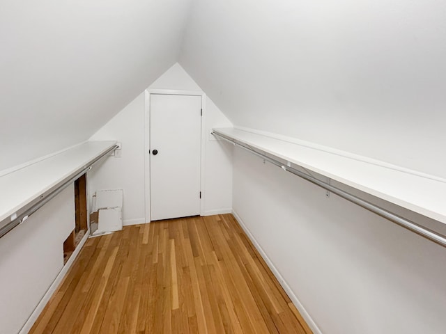 spacious closet with lofted ceiling and light hardwood / wood-style floors