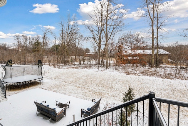 snowy yard featuring a trampoline