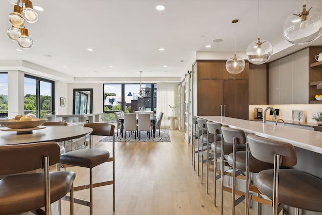 dining space featuring sink, plenty of natural light, a barn door, and light hardwood / wood-style floors