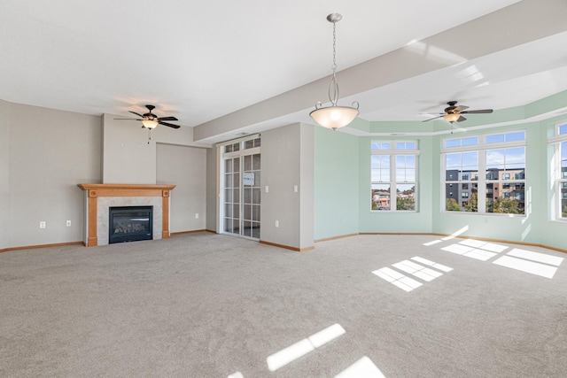 unfurnished living room featuring a fireplace, light colored carpet, and ceiling fan