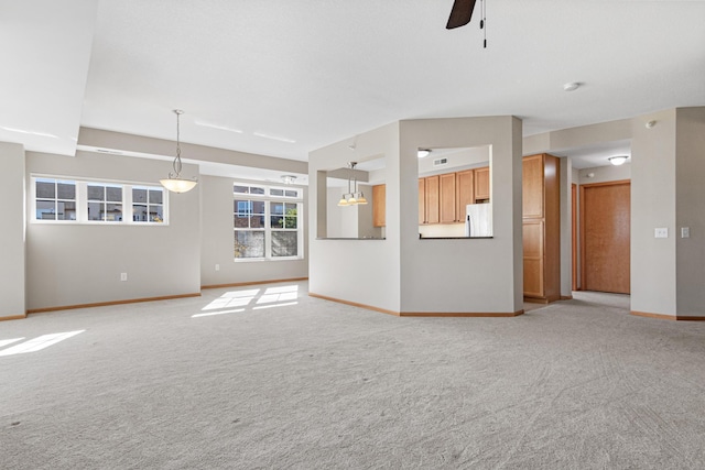 unfurnished living room with light carpet and ceiling fan with notable chandelier