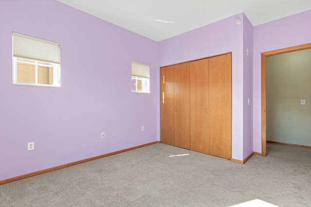 unfurnished bedroom with light carpet and a closet