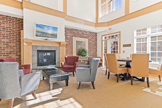 living room featuring carpet flooring, a high ceiling, and a tiled fireplace