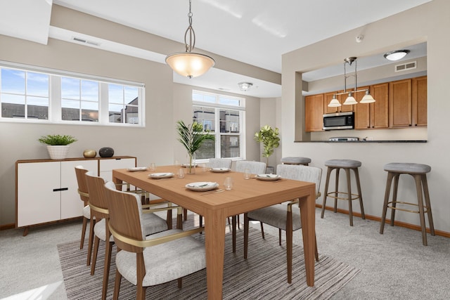 dining room featuring light carpet, visible vents, and baseboards