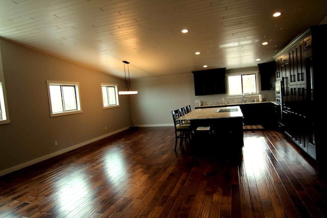 dining space featuring dark hardwood / wood-style flooring, a healthy amount of sunlight, and vaulted ceiling