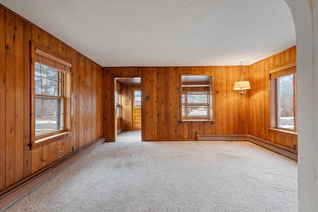 unfurnished room with carpet floors, a textured ceiling, and baseboard heating