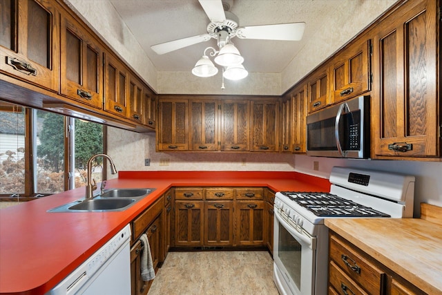 kitchen with sink, white appliances, and ceiling fan