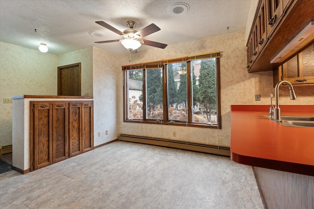 interior space with sink, a baseboard radiator, and a textured ceiling