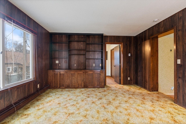 unfurnished living room with wooden walls and a wealth of natural light