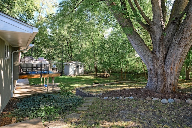 view of yard with a wooden deck, a shed, and an outdoor structure