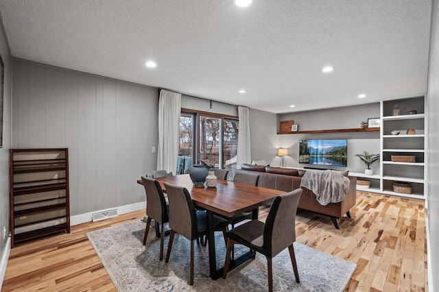 dining area with a textured ceiling, recessed lighting, visible vents, baseboards, and light wood finished floors