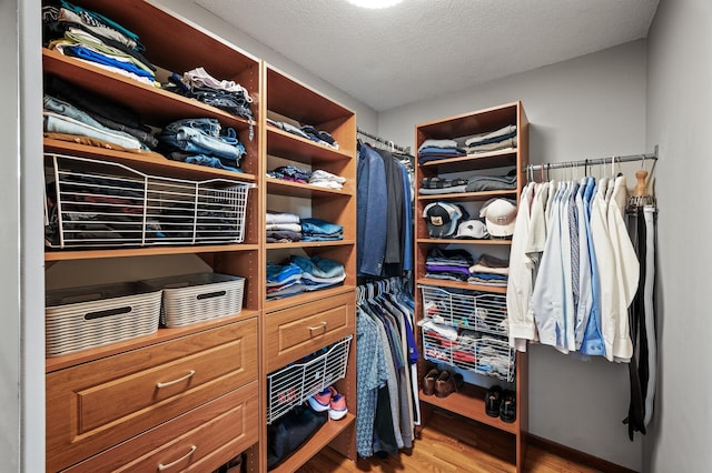 walk in closet with wood finished floors